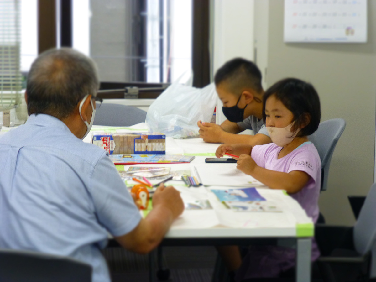 託児室で、お孫さんのような子供たちにお絵かきを教える、オーナー会菅生会長