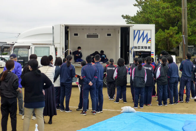 転がりながらも、地震体験車両内で地震を体験する西淡中学の生徒たち。