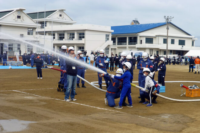 消防団員のサポートで放水訓練を行う、中学生たち。