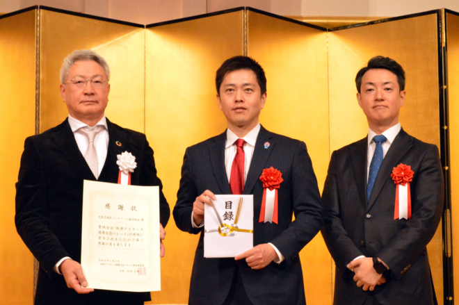 阪神タイガース優勝パレードに対する寄付への感謝状を持つ大阪兵庫工組・大阪広域協組両理事長 木村貴洋氏（左）、寄付目録を持つ大阪府知事 吉村洋文氏（中央）と大阪市長 横山英幸氏。