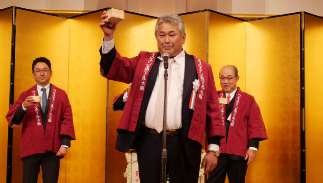 乾杯の音頭をとる大阪広域協組の副理事長 大山正芳氏（下・中央）。